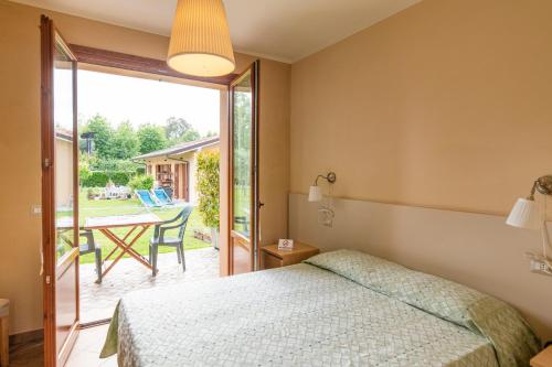 ein Schlafzimmer mit einem Bett und eine Terrasse mit einem Tisch in der Unterkunft Villa Rosy in Torre del Lago Puccini