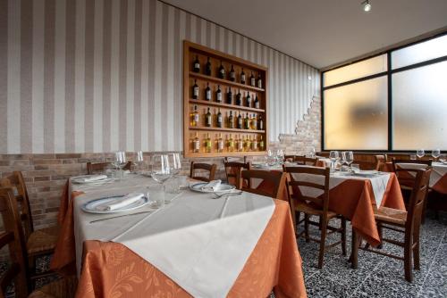 a dining room with tables and chairs and wine bottles at Hotel Le Terrazze di Nappino in Trespiano