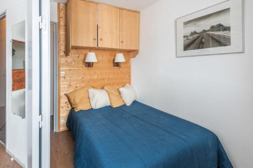 a bedroom with a bed with a blue blanket at Residence Les Fontaines Blanches - maeva Home in Avoriaz