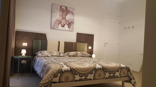 a bedroom with a bed and a picture on the wall at Dolce Vita in Zafferana Etnea