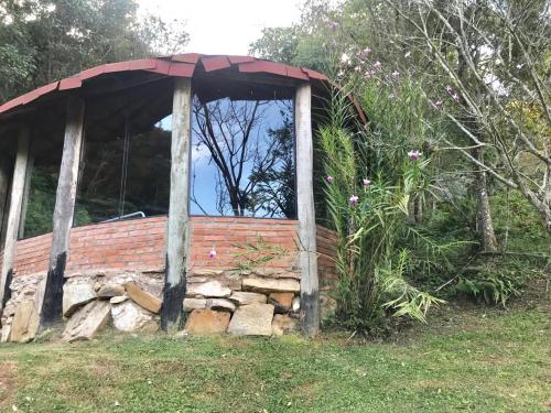 a building with a red roof on top of a pile of rocks at Pousada Recanto da Siriema in Monte Alegre do Sul
