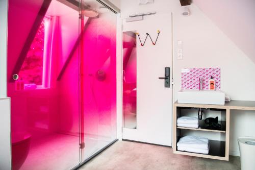 a bathroom with pink walls and a shower at Hotel Bruno in Middelburg