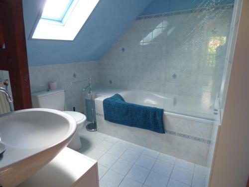 La salle de bains est pourvue d'une baignoire, de toilettes et d'un lavabo. dans l'établissement Gîte Le Petit Chalet avec parking gratuit, à Étretat