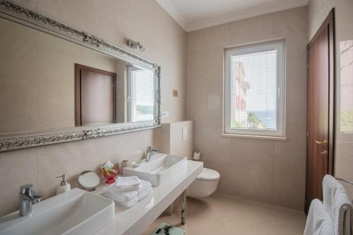 a bathroom with two sinks and a mirror and a toilet at Stone House Buljanovic in Sali