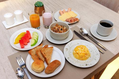 a table with plates of breakfast food on it at Hotel American Visa Tower in Bogotá