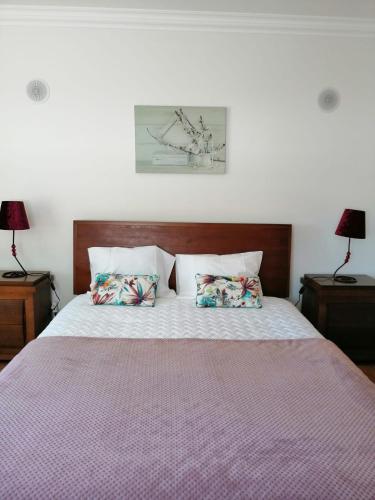 a bedroom with a bed with two pillows on it at D´YELLOW HOUSE - Beach and Countryside in Carqueja