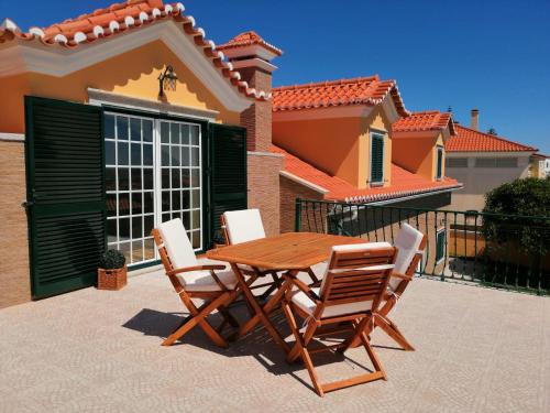 a wooden table and chairs in front of a house at D´YELLOW HOUSE - Beach and Countryside in Carqueja