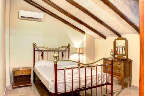 ein Schlafzimmer mit einem Bett, einer Kommode und einem Spiegel in der Unterkunft Villa Brigadoon Corfu in Agios Ioannis Peristerion