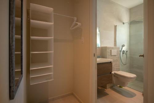 y baño con aseo, lavabo y ducha. en Hideout Suites - from Eagle Beach, en Palm-Eagle Beach