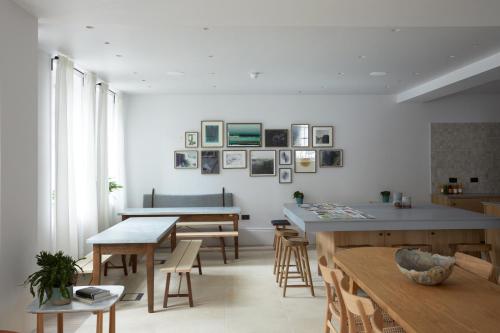 a dining room with tables and chairs and pictures on the wall at Inhabit Southwick Street, a Member of Design Hotels in London
