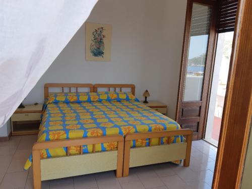a bedroom with a bed in a room with a window at Baia Unci in Canneto