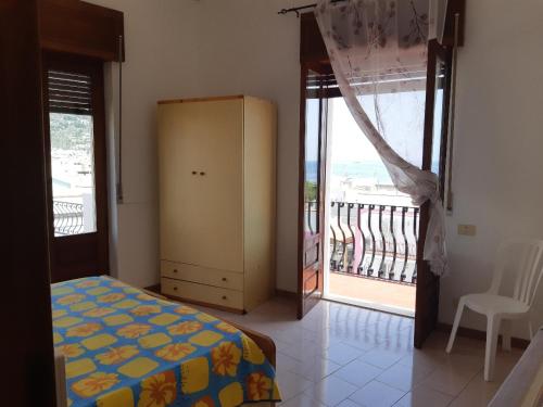 a bedroom with a bed and a balcony at Baia Unci in Canneto