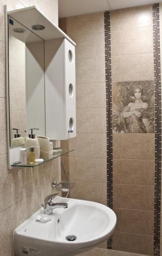 a bathroom with a sink and a mirror at Cosmo Apartment Pleven in Pleven