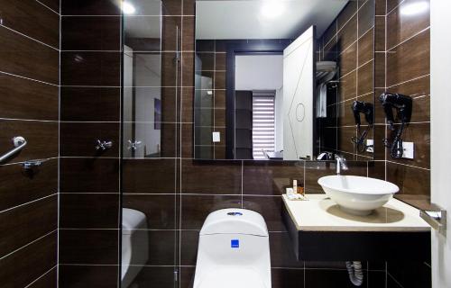 y baño con aseo y lavamanos. en Hotel American Visa Tower, en Bogotá