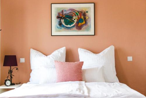 a bed with white pillows and a picture on the wall at Torrinha House in Lagos