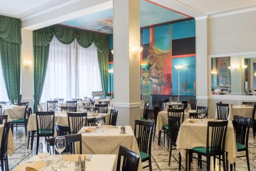 a dining room filled with tables and chairs at Hotel Minerva Palace in Montecatini Terme