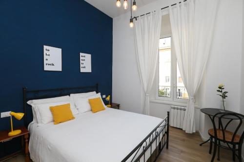 - une chambre avec un grand lit et un mur bleu dans l'établissement Vatican Garden Rooms, à Rome