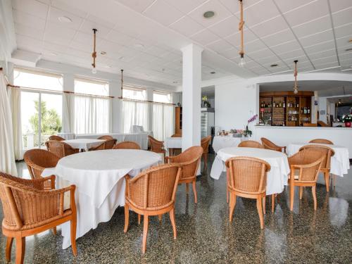 a dining room with white tables and chairs at Hotel Altaia in Altea