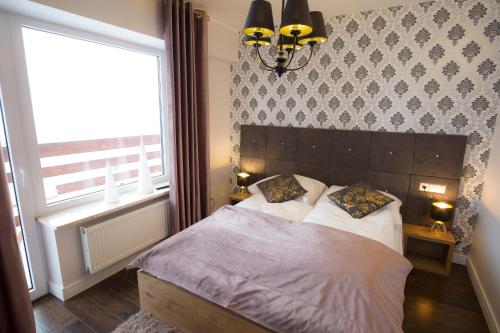 a bedroom with a bed with two pillows on it at Apartamenty Ciche Wzgórze Zakopane in Zakopane