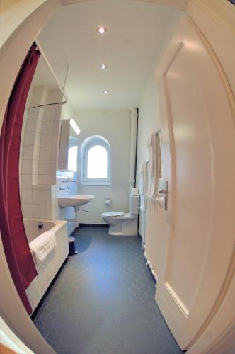 a bathroom with a large circular window and a mirror at Spacious 2-bedroom near lake - Stardust 32 in Zurich
