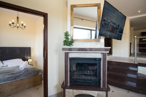 a bedroom with a fireplace and a bed and a mirror at Apartamenty Ciche Wzgórze Zakopane in Zakopane