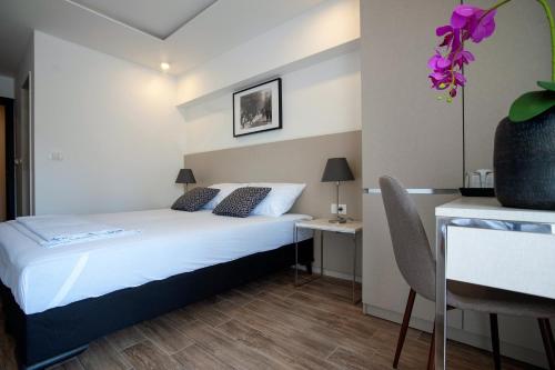 a bedroom with a bed and a table with a chair at Casa Mia in Budva