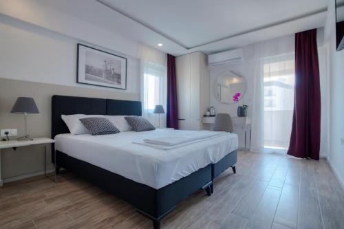 a bedroom with a large bed and a desk and window at Casa Mia in Budva