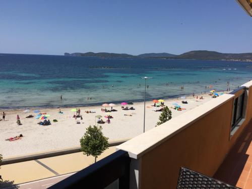 a view of a beach with people in the water at Appartamenti Sole 1 in Alghero