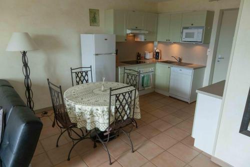 La cuisine est équipée d'une table, de chaises et d'un réfrigérateur blanc. dans l'établissement Gordes Le Bastidon, à Gordes