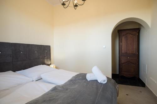 a bedroom with a bed with white sheets and a chandelier at Apartamenty Ciche Wzgórze Zakopane in Zakopane