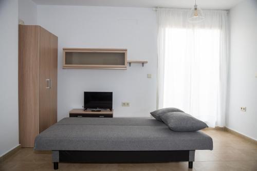 ein Schlafzimmer mit einem Bett und einem TV an der Wand in der Unterkunft Apartamento con vistas al mar en Torre de la Horadada in Pilar de la Horadada