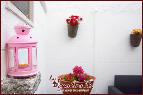 a pink lantern sitting on a rock with flowers at "B&B La Lanterna" Trulli & Dimore Storiche in Alberobello