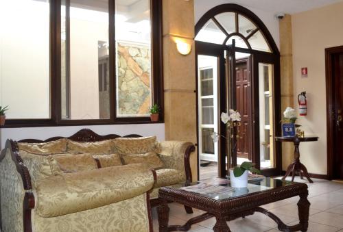 a living room with a couch and a table at Hotel Villa Florencia Zona Rosa in San Salvador