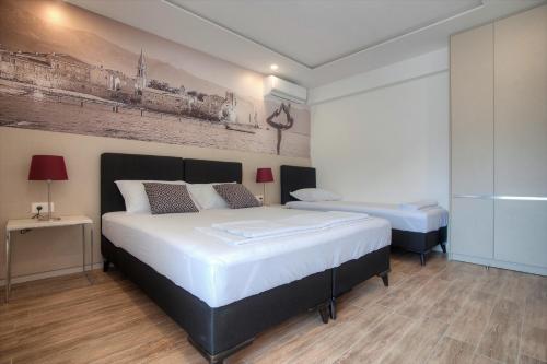 a bedroom with two beds and a painting on the wall at Casa Mia in Budva
