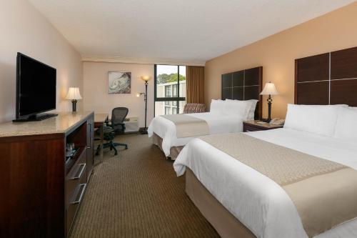 a hotel room with two beds and a flat screen tv at Wyndham Riverfront Hotel in Little Rock