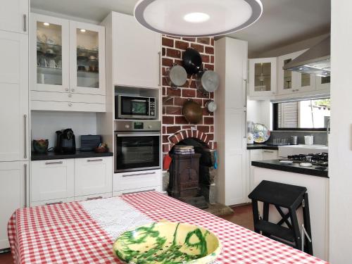 a kitchen with a table and a brick fireplace at Casa do Avô Xico - Gerês Lake House - 10pax in Geres
