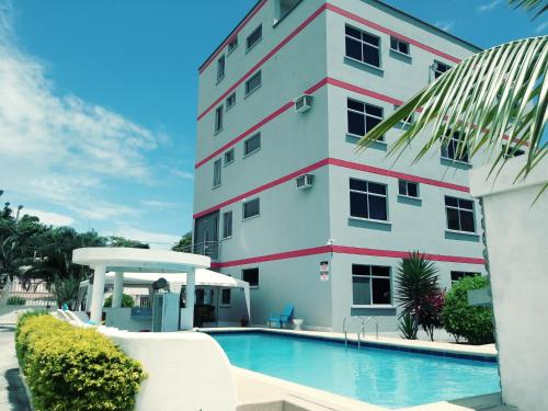 un bâtiment avec une piscine en face d'un bâtiment dans l'établissement Hotel Salduba, à Tonsupa
