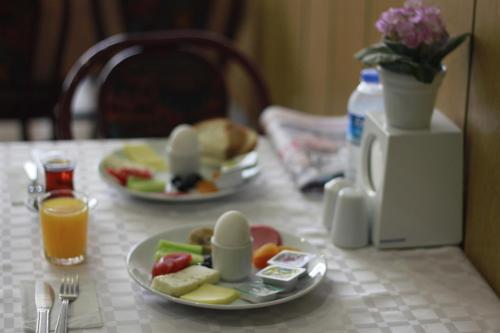 a table with two plates of food and orange juice at Acikgoz Hotel in Edirne
