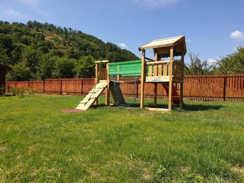 a playground with a slide in the grass at Kalabash Apartments in Sovata