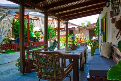 a patio with a wooden table and chairs on a porch at Epohikon Studios in Sarti