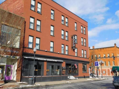 a large red brick building on a street corner at The Gould Hotel in Seneca Falls