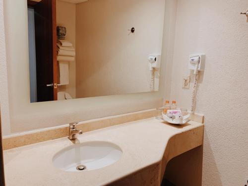 a bathroom with a sink and a mirror at Hotel Mercury Inn in Querétaro