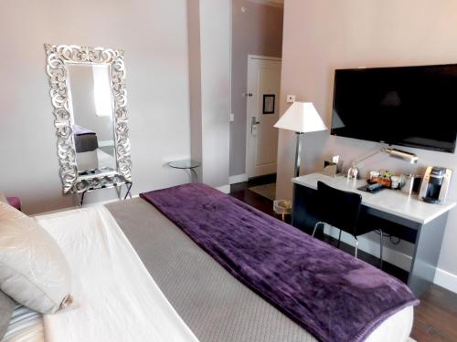 a bedroom with a bed with a desk and a mirror at The Gould Hotel in Seneca Falls