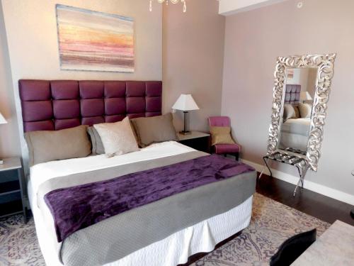 a bedroom with a large bed and a mirror at The Gould Hotel in Seneca Falls