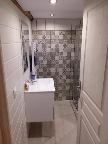 une salle de bain avec un lavabo blanc et un miroir dans l'établissement le Woody, à Saint-Étienne-de-Tinée