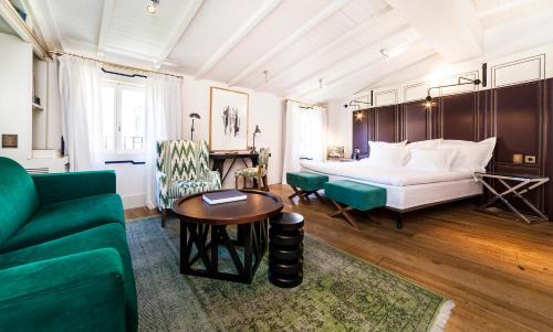 a bedroom with a bed and a couch and a table at Hotel Cort in Palma de Mallorca