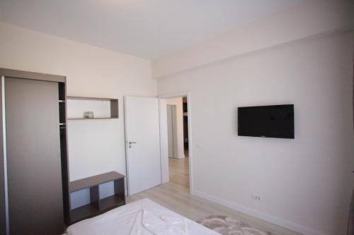 ein Wohnzimmer mit einem TV an einer weißen Wand in der Unterkunft Luiza Apartament - Bavaro Residence - Mamaia Nord in Mamaia Nord – Năvodari