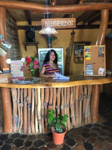 a woman is sitting at a counter in a restaurant at Hostal Rutamar in Canoa