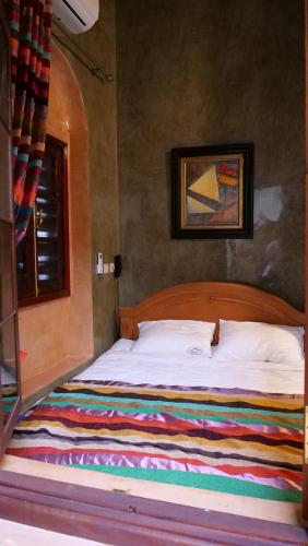 a bedroom with a bed with a colorful blanket on it at Ryad 91 in Casablanca