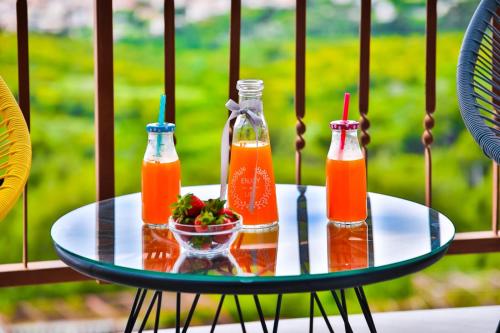 two bottles of juice and a bowl of fruit on a table at Sun Apartment Klis in Klis
